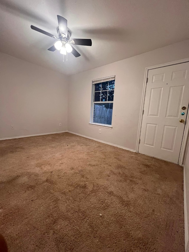 empty room featuring ceiling fan, carpet floors, and baseboards