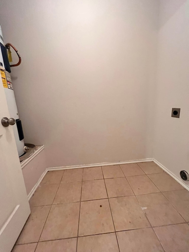 laundry area with laundry area, baseboards, electric dryer hookup, and light tile patterned flooring