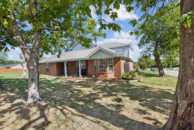 ranch-style house featuring brick siding, fence, and a front lawn