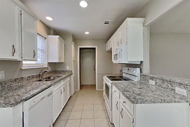 kitchen featuring white appliances, visible vents, white cabinetry, and a sink