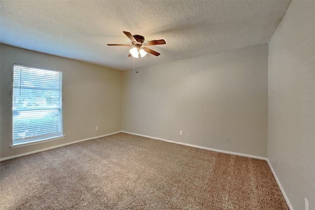 carpeted empty room featuring ceiling fan, a textured ceiling, and baseboards