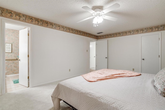 bedroom featuring light colored carpet, a textured ceiling, and baseboards