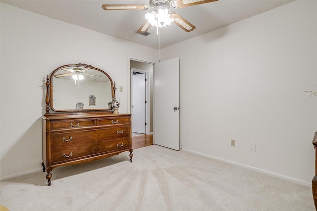 bedroom featuring light carpet, ceiling fan, visible vents, and baseboards