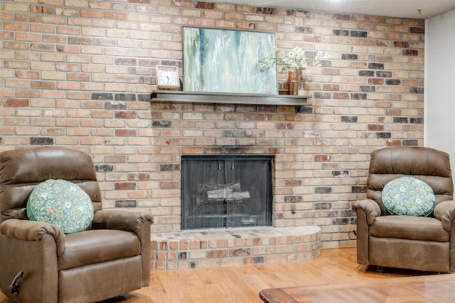 living area featuring a brick fireplace and wood finished floors