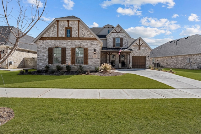 french provincial home featuring an attached garage, brick siding, concrete driveway, a standing seam roof, and a front yard