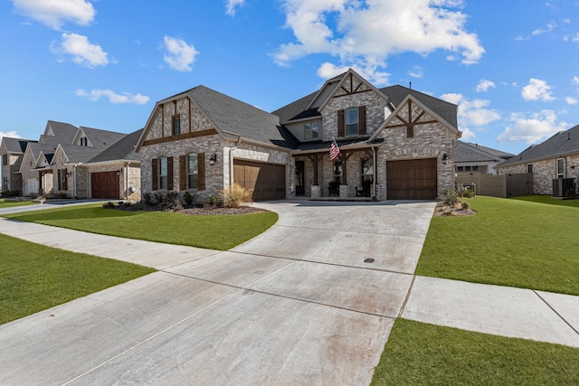 view of front of house featuring a shingled roof, concrete driveway, an attached garage, central air condition unit, and a front yard