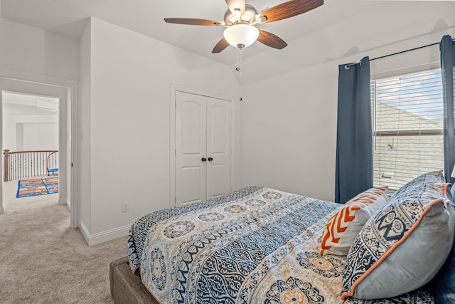 carpeted bedroom featuring a ceiling fan, lofted ceiling, a closet, and baseboards