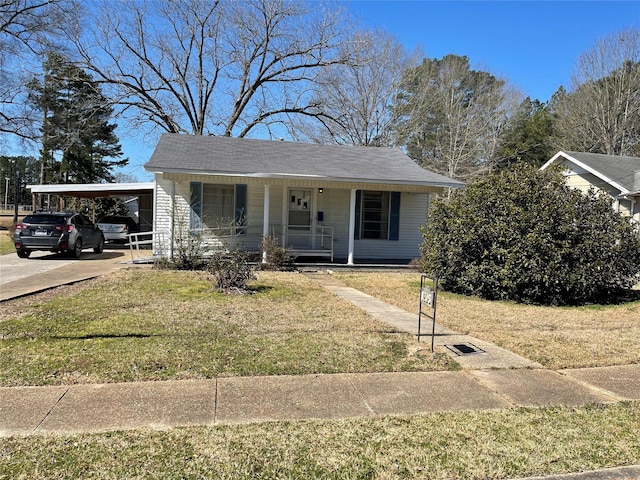 bungalow-style house with concrete driveway, a porch, a carport, and a front yard