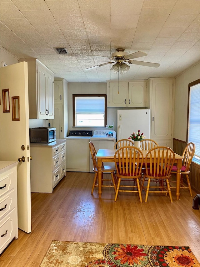 dining area featuring a ceiling fan, light wood-type flooring, washer / clothes dryer, and visible vents