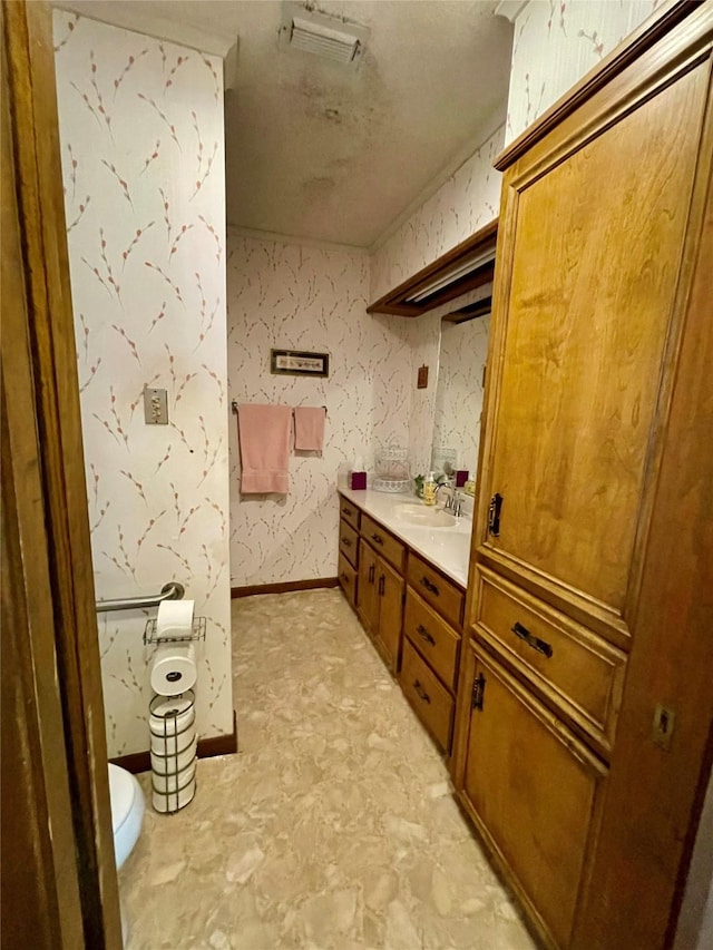 bathroom featuring wallpapered walls, visible vents, baseboards, toilet, and vanity