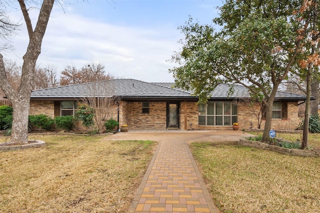 view of front of house with brick siding and a front lawn