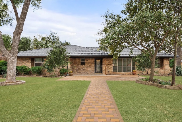 rear view of property with a lawn and brick siding