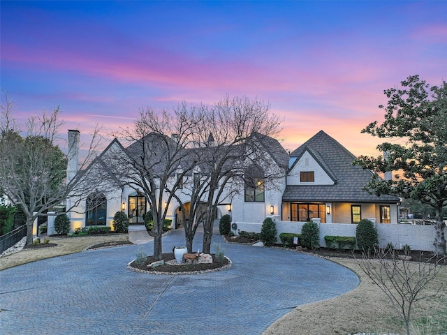 view of front of home featuring curved driveway and brick siding