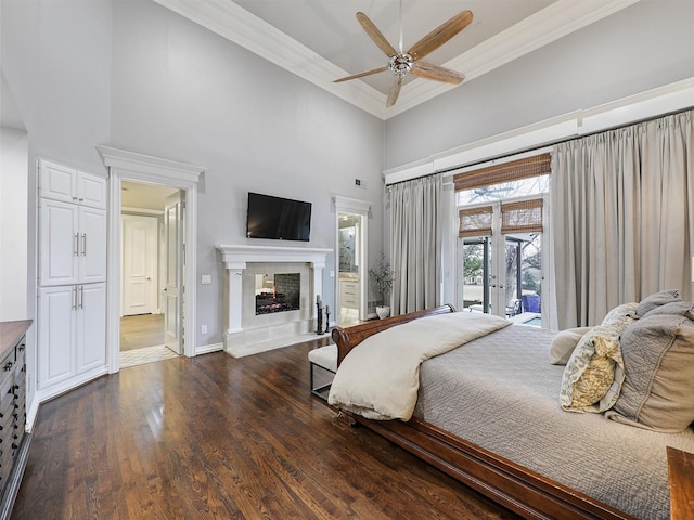 5030 Southern Hills Dr, Frisco, TX 75034 - bedroom with dark wood-type flooring, crown molding, a high ceiling, a multi sided fireplace, and access to exterior