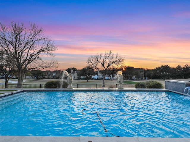 view of swimming pool featuring fence