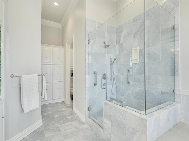 bathroom with ornamental molding, a shower stall, baseboards, and a spacious closet