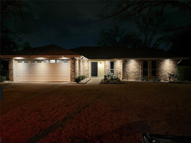 view of front of house featuring a yard, stone siding, driveway, and an attached garage