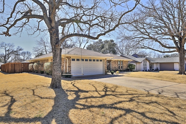 view of front of house with brick siding, an attached garage, fence, driveway, and a front lawn