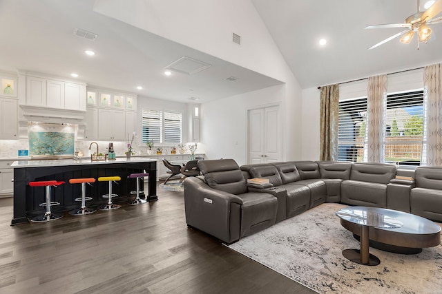 living area with high vaulted ceiling, recessed lighting, dark wood-type flooring, visible vents, and a ceiling fan