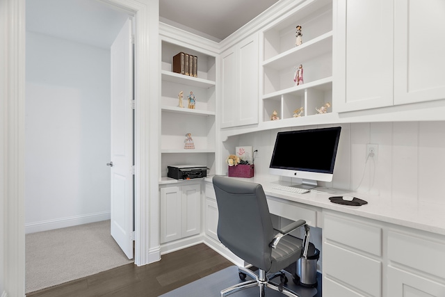 office area with dark wood-style flooring, built in study area, and baseboards