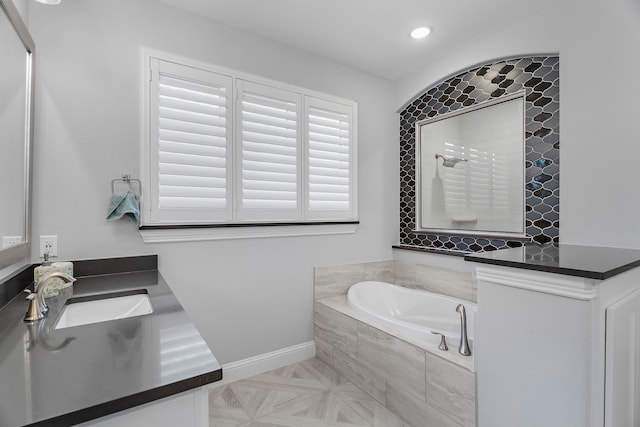 full bathroom featuring a garden tub, recessed lighting, a tile shower, vanity, and baseboards