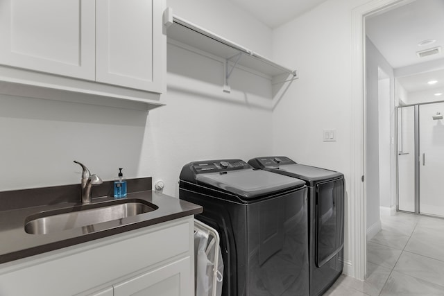 laundry area with cabinet space, visible vents, baseboards, washer and dryer, and a sink