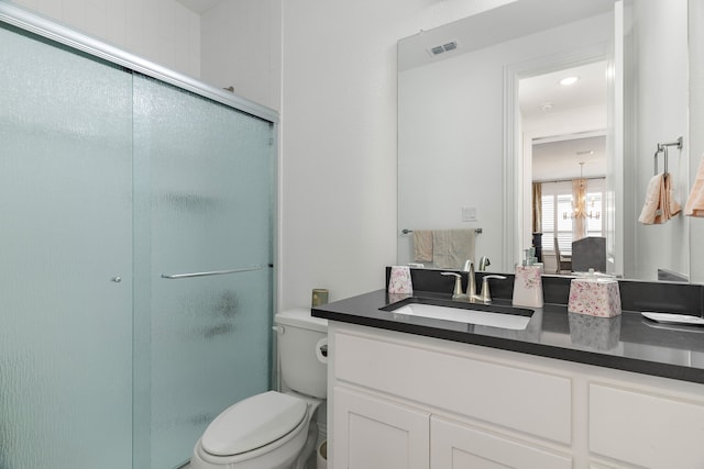 full bathroom featuring a chandelier, toilet, vanity, visible vents, and a shower stall