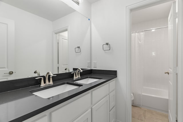 full bathroom featuring shower / tub combo with curtain, a sink, toilet, and double vanity