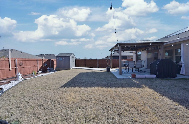 view of yard with a storage shed, a patio, a fenced backyard, an outbuilding, and a gazebo