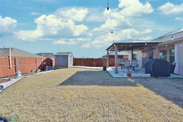 view of yard featuring an outbuilding, a patio, a fenced backyard, a gazebo, and a storage unit