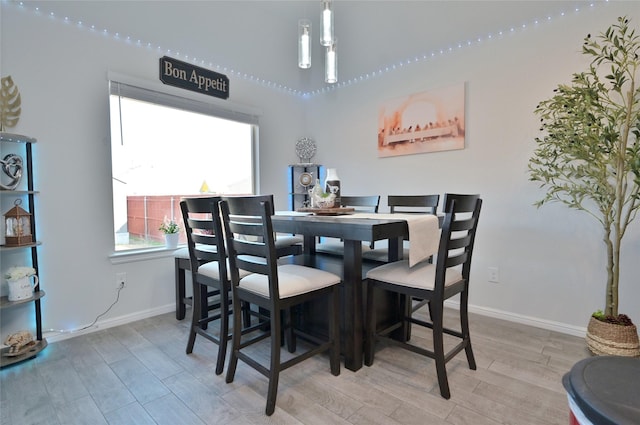 dining space with baseboards and wood finished floors