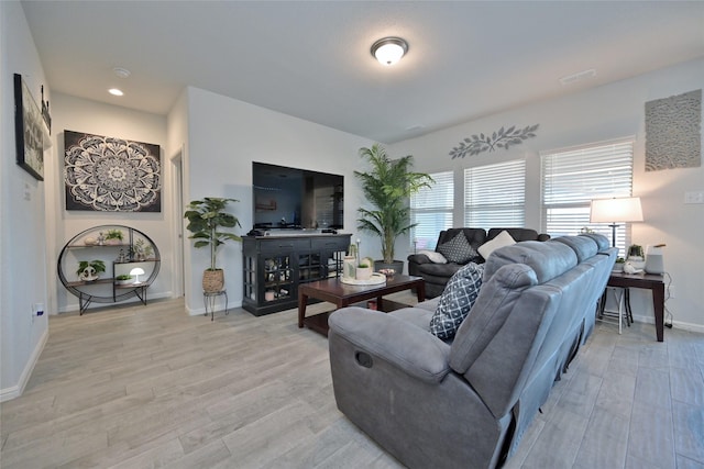 living room with light wood-style floors, baseboards, and visible vents