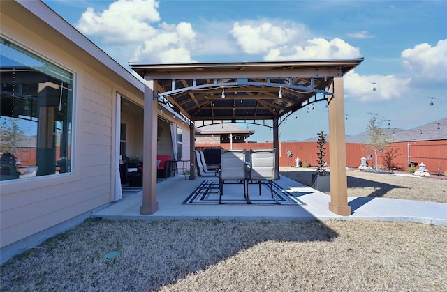 view of patio with a gazebo, outdoor dining area, and a fenced backyard