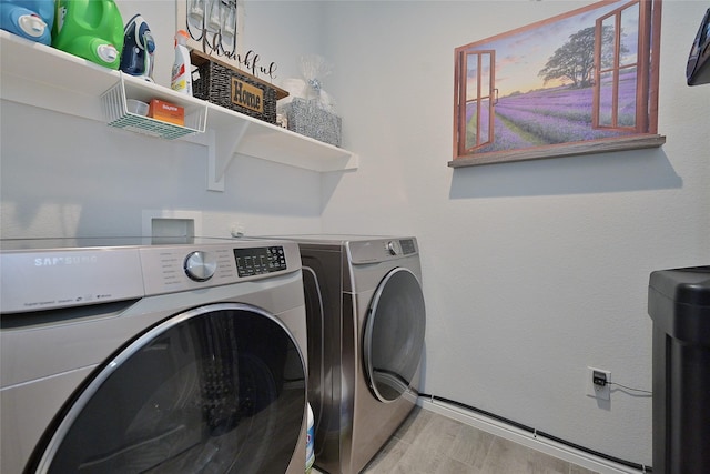 laundry area featuring laundry area, independent washer and dryer, and wood finished floors