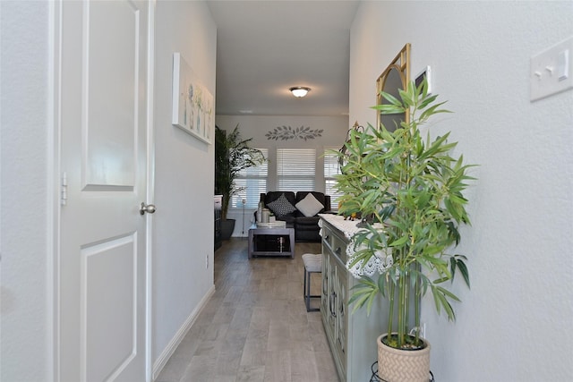 hall featuring baseboards and light wood finished floors