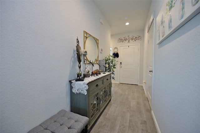 doorway to outside featuring light wood finished floors, recessed lighting, and baseboards