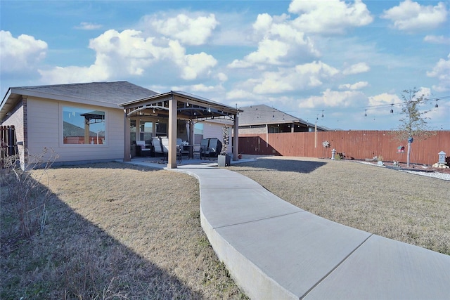 back of property with a patio area, a fenced backyard, a yard, and a gazebo