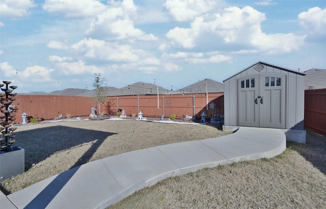 view of yard featuring a fenced backyard, a storage unit, and an outdoor structure