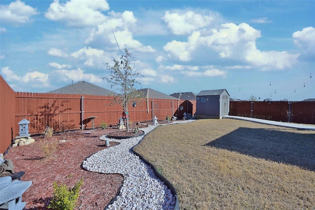 view of yard with a storage unit, an outdoor structure, and a fenced backyard