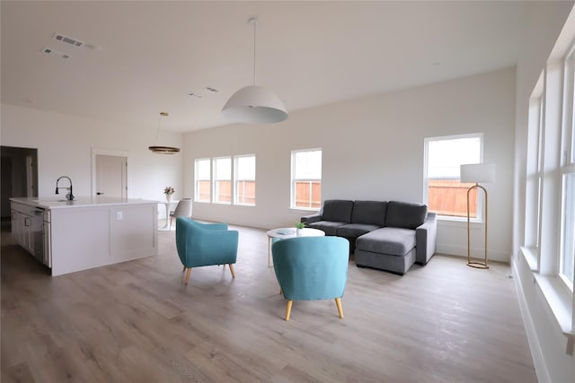 living area with visible vents and light wood-style floors