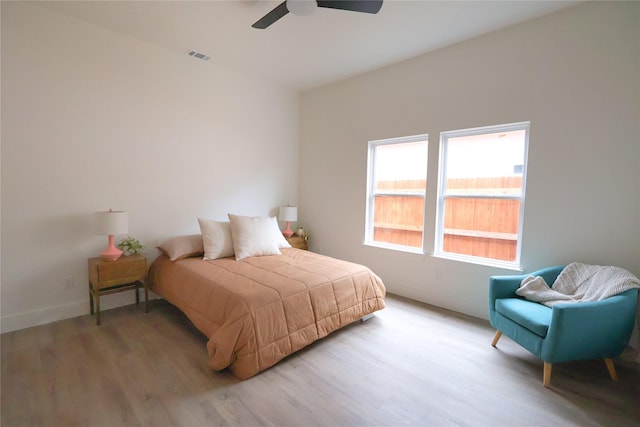 bedroom featuring light wood-type flooring, visible vents, ceiling fan, and baseboards