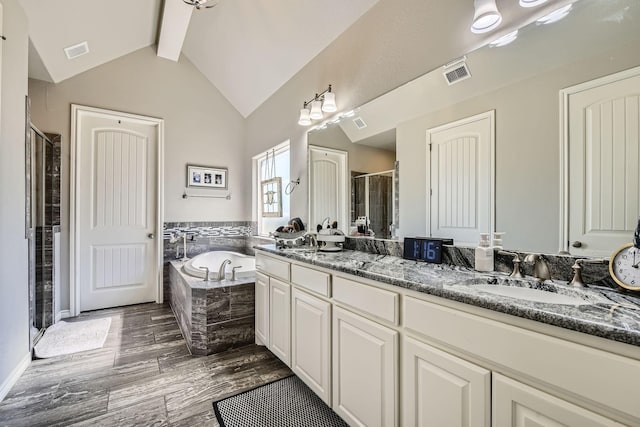 bathroom featuring lofted ceiling with beams, visible vents, a sink, and a bath