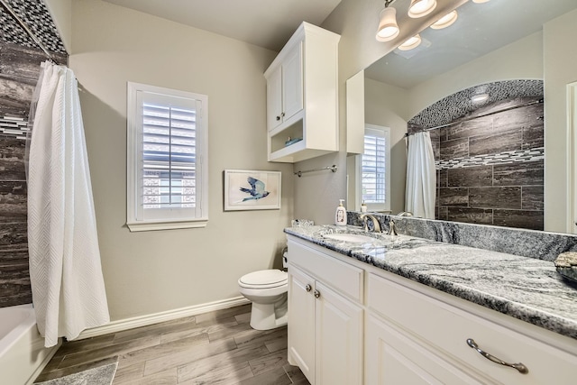 full bath featuring toilet, wood finish floors, vanity, baseboards, and shower / bath combination with curtain