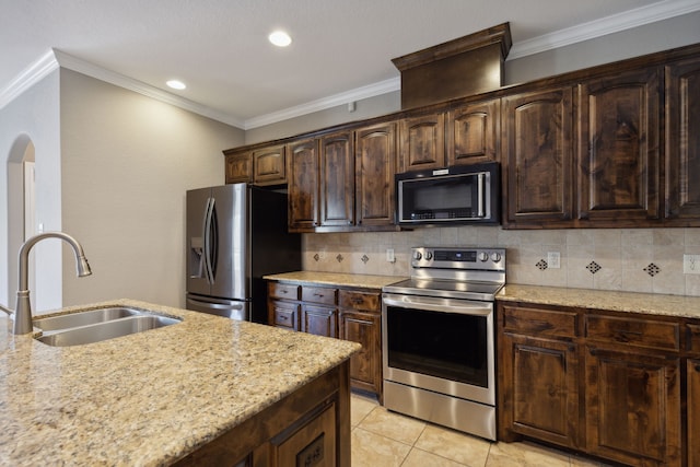 kitchen with dark brown cabinetry, backsplash, stainless steel appliances, and a sink