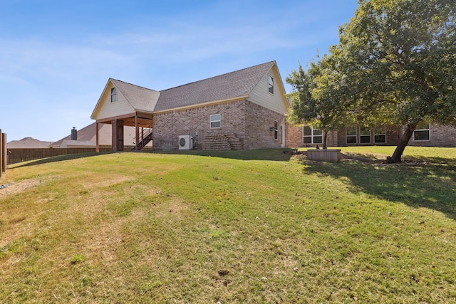 view of home's exterior with brick siding, stairway, fence, and a yard