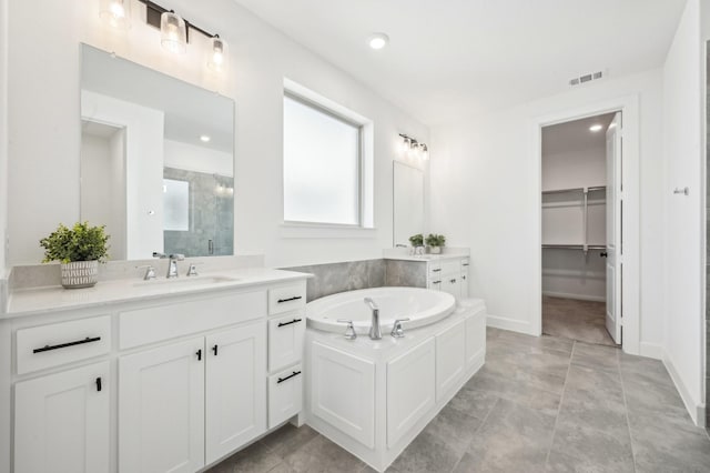 full bathroom with a sink, two vanities, visible vents, a spacious closet, and a shower stall