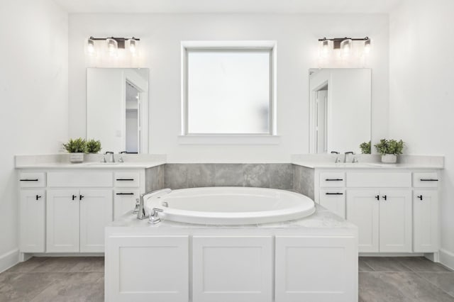 full bathroom featuring two vanities, tile patterned flooring, a garden tub, and a sink