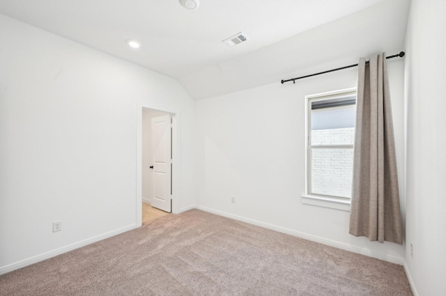 spare room featuring light carpet, visible vents, baseboards, lofted ceiling, and recessed lighting