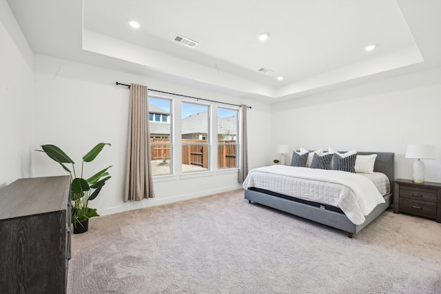 bedroom with light carpet, a raised ceiling, visible vents, and recessed lighting