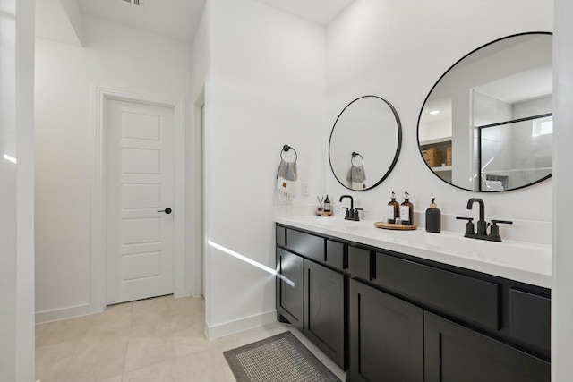 full bath with double vanity, baseboards, a shower with door, and a sink